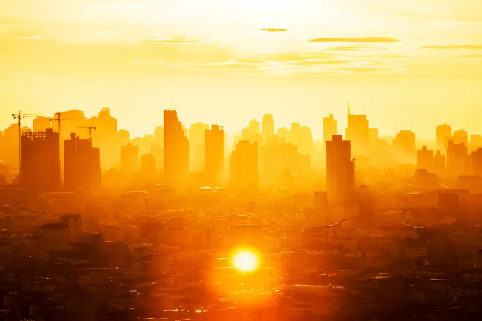 View of buildings in Bangkok business district through extremely orange sunlight